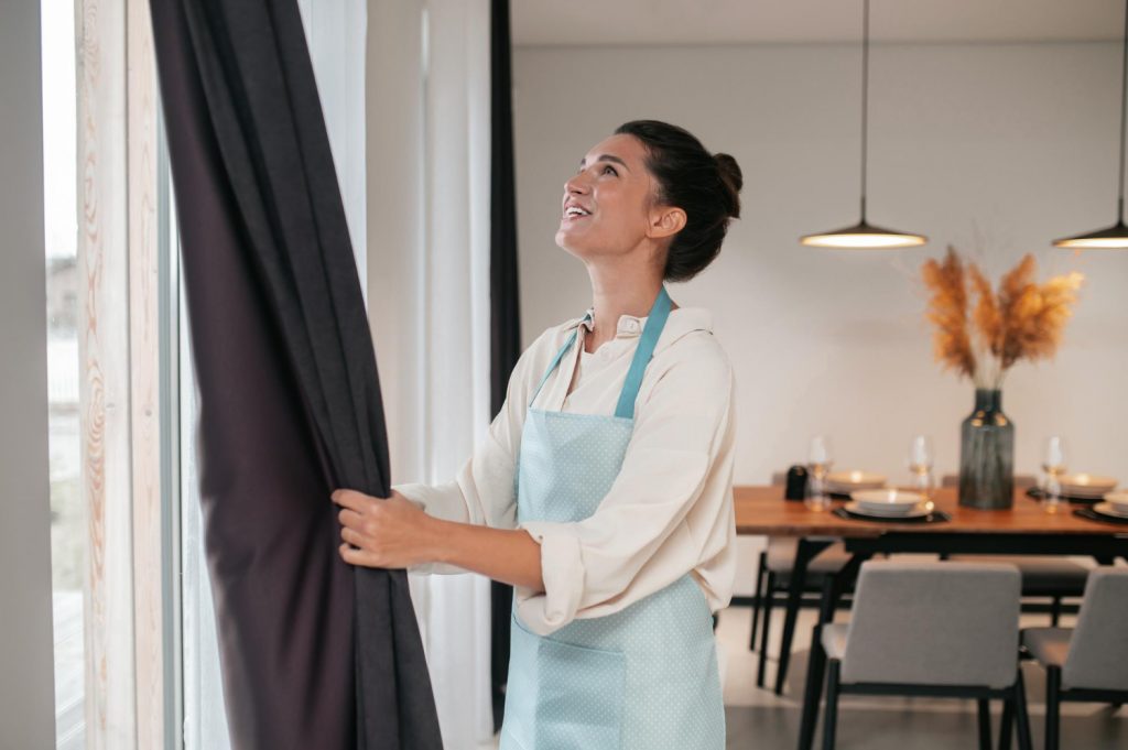 Medida de cortina: mulher ajustando cortina