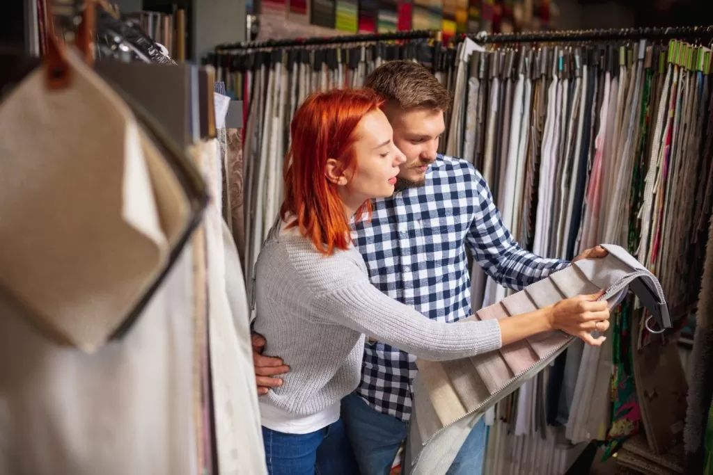 Como comprar cortina para sala: casal analisando tons para cortina